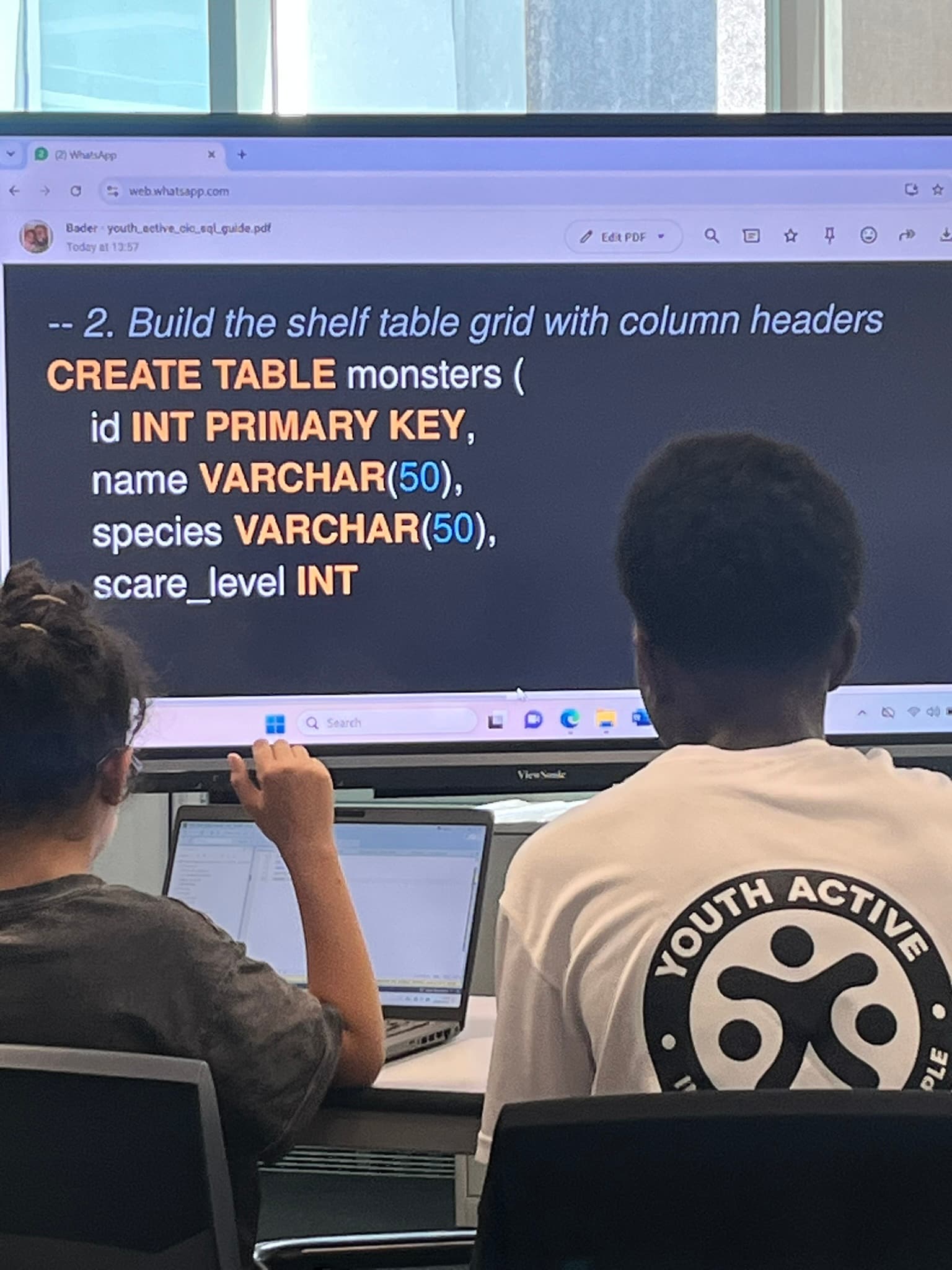 Young people at a Youth Active coding session, working through an SQL lesson