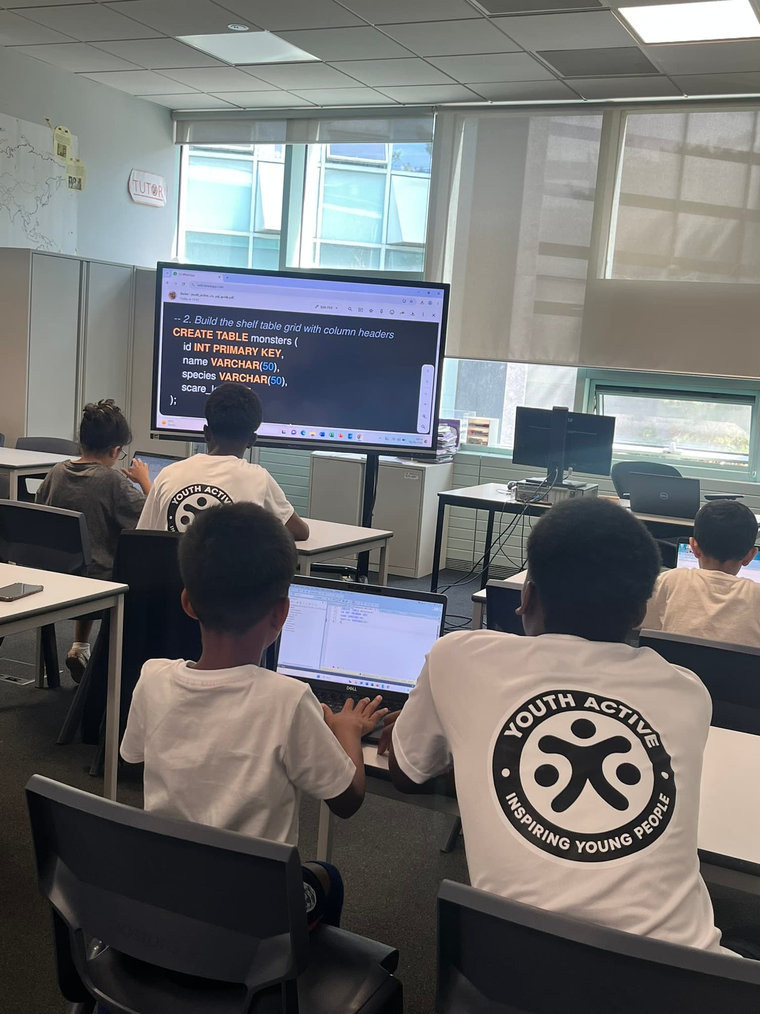 Young people at a coding session, working through SQL exercises together