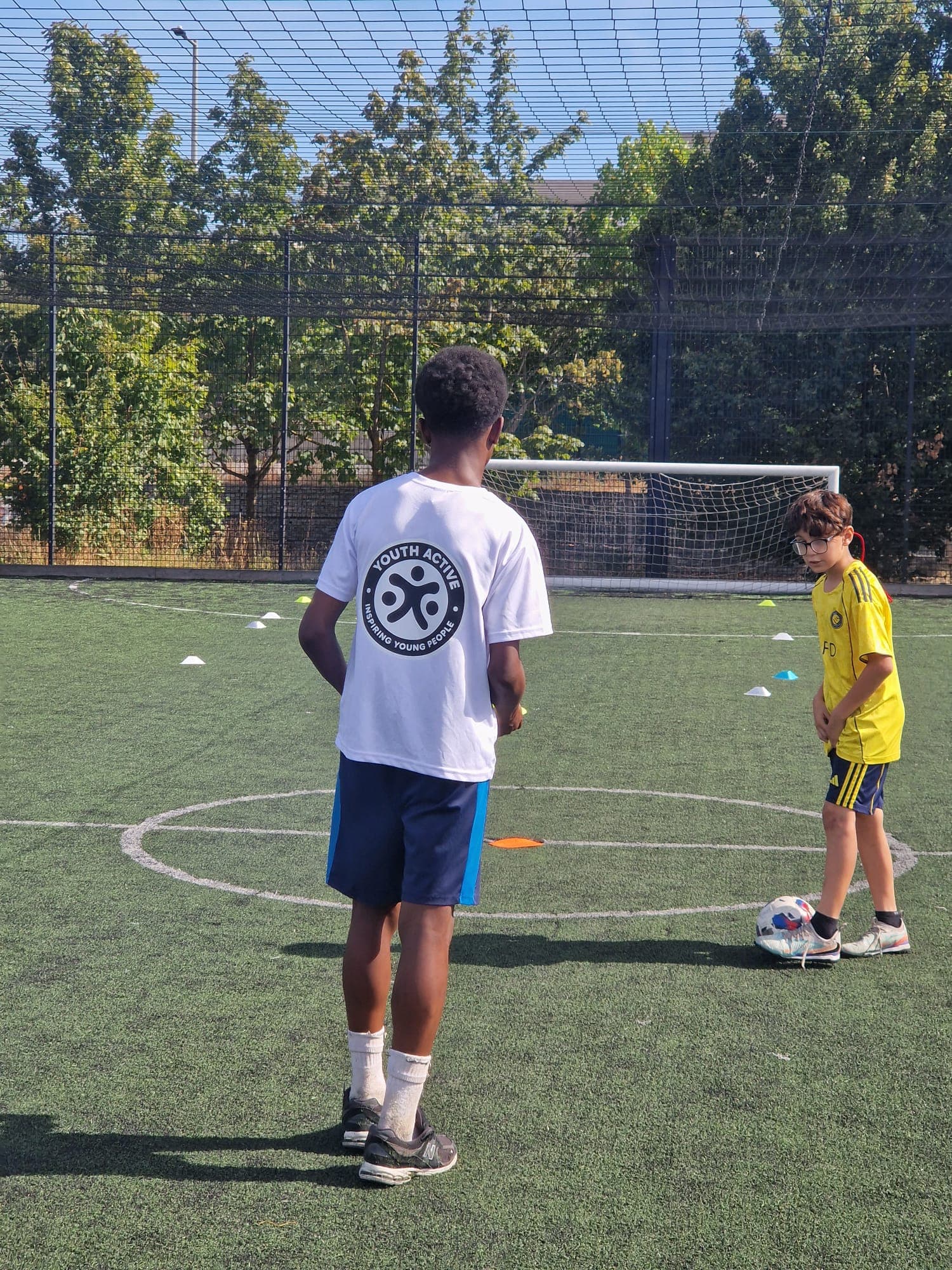 A Youth Active coach and young players during a football drill